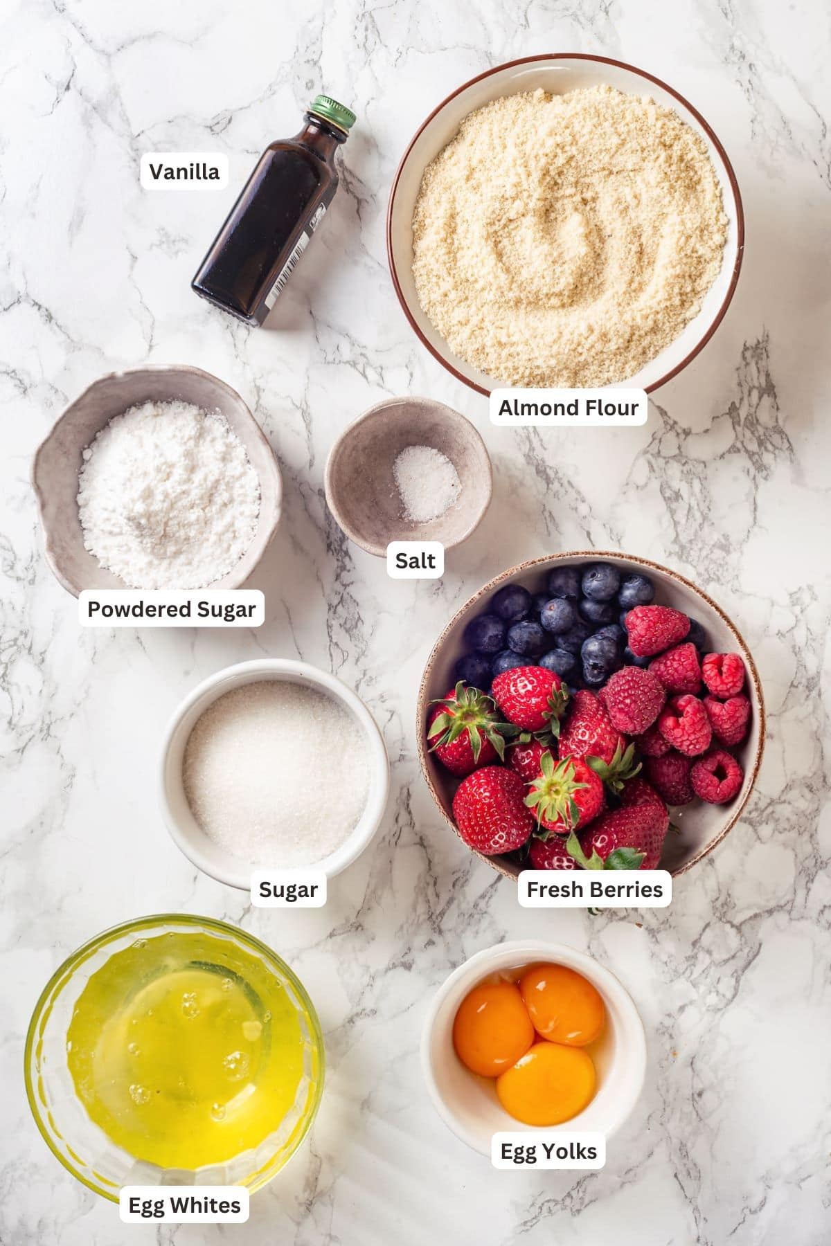 This easy almond cake recipe is made with just 5 ingredients but don't let its simplicity fool you—it's light, airy, and so delicious! Ingredients for gluten free almond cake on a marble background.