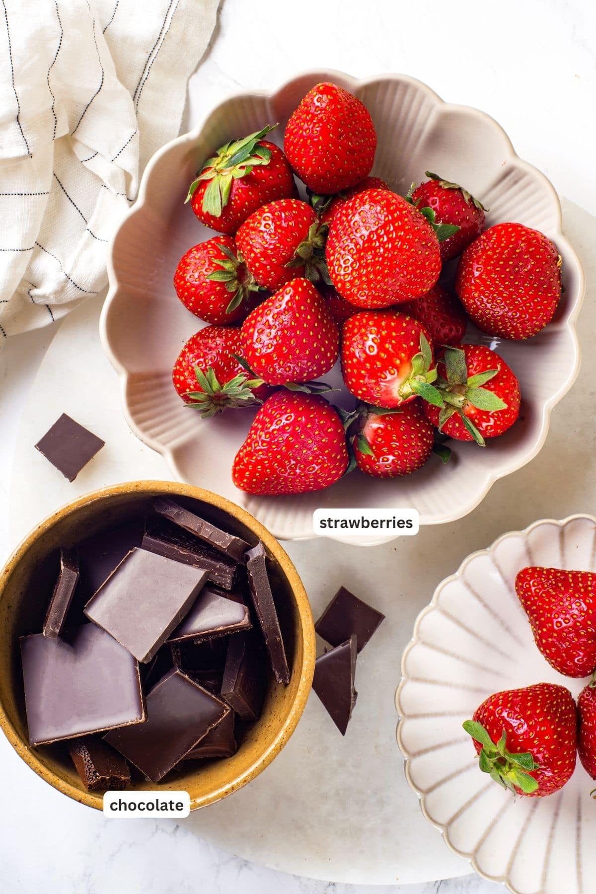 Chocolate-covered strawberries are an elegant treat that's incredibly easy to make at home. You'll never buy them at the store again! Overhead view of ingredients for chocolate-covered strawberries with labels