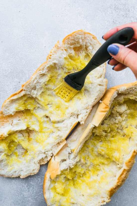 Scoop out the inside of the bread and brush with olive oil.