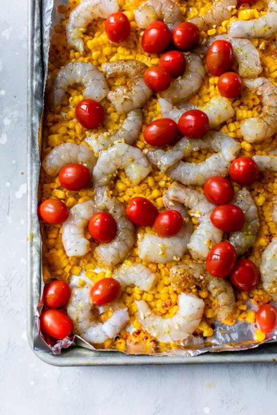 Baking sheet with corn, shrimp and tomatoes.