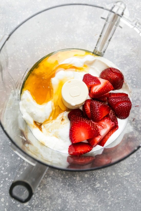 food processor with yogurt, honey and strawberries