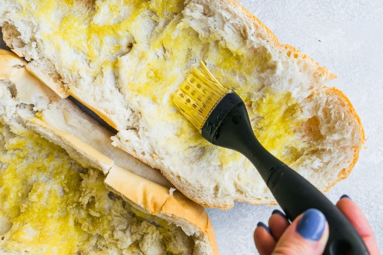 Scoop out the inside of the bread and brush with olive oil.