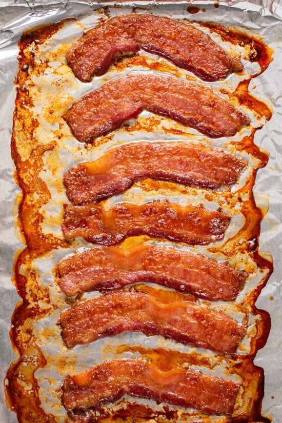 Whether you're a fan of tender, crisp, or extra crispy bacon, this simple method of cooking bacon in the oven is easy. No stovetop mess! Cooked bacon on foil.