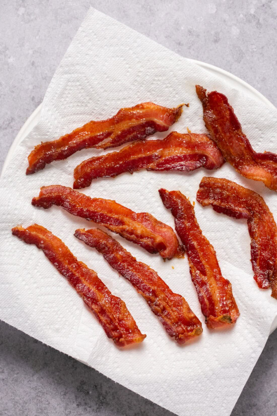 Whether you're a fan of tender, crisp, or extra crispy bacon, this simple method of cooking bacon in the oven is easy. No stovetop mess! bacon on a paper towel-lined plate