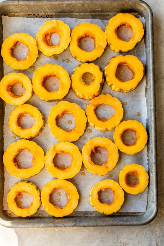 Place the delicata squash on a rimmed baking sheet with parchement.