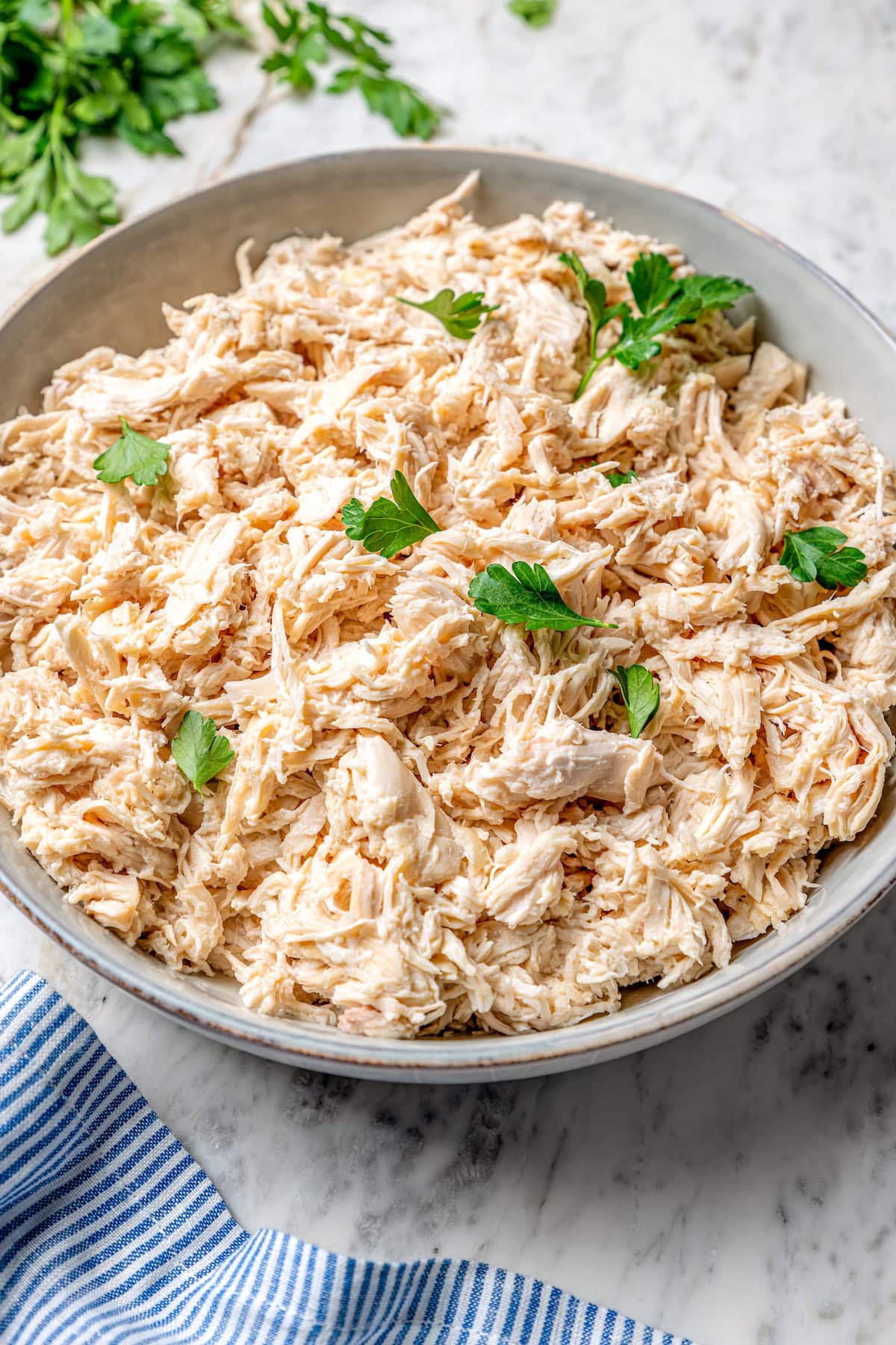 This slow cooker shredded chicken recipe is juicy, tender, and flavorful. It's a hands-off cooking method perfect for meal prep! Bowl of crockpot shredded chicken
