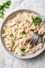 Bowl of crockpot shredded chicken with 2 forks