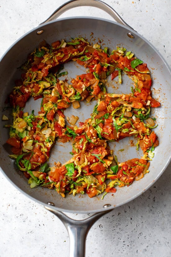 brussels and tomatoes, making wells in a skillet