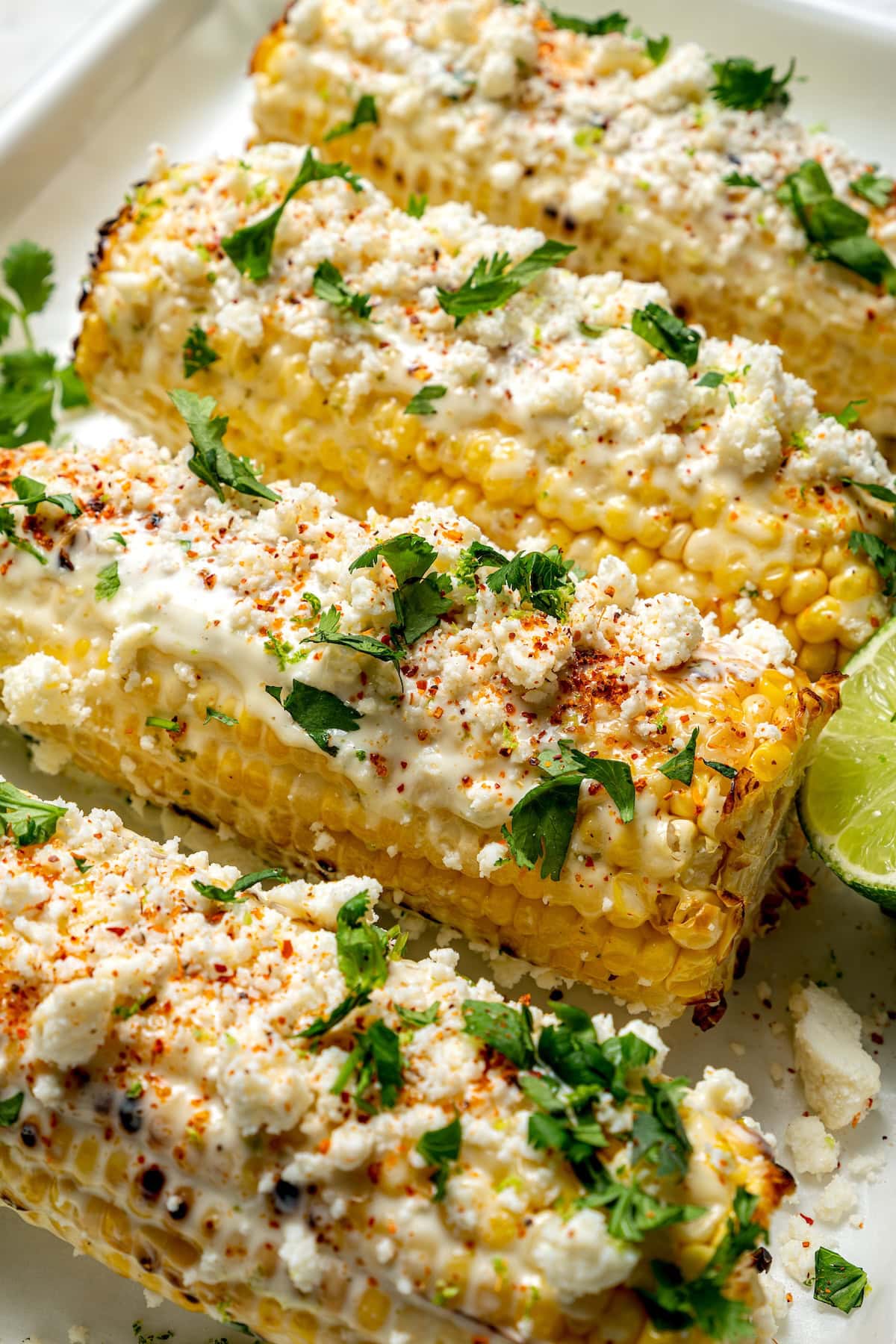 This lighter version of the classic grilled Mexican street corn recipe has all the flavor of the original, with mayo, cotija, lime and Tajín! 4 ears of Mexican street corn with lime mayo, cotija, Tajin, and cilantro