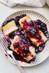 Cooked cheese blintzes on plate with blueberry sauce
