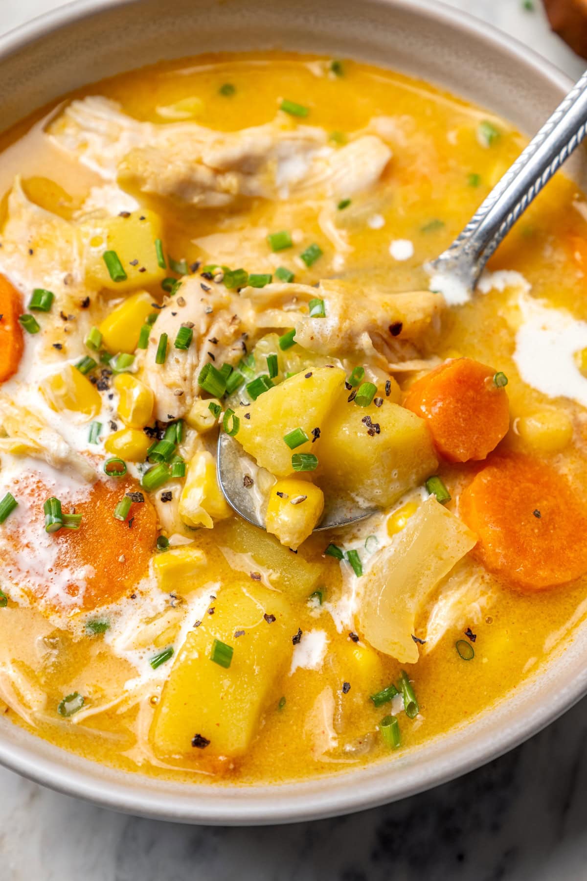 Bowl of chicken corn chowder with spoon.