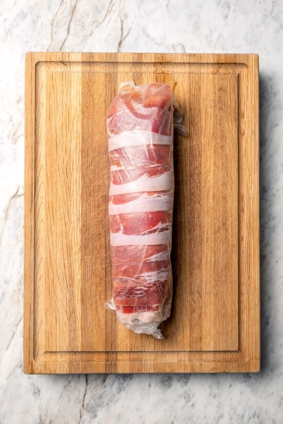 This Prosciutto Wrapped Stuffed Turkey Tenderloin recipe is filled with apples, cheese and kale for a healthy high-protein dinner. Delicious! Turkey tenderloin wrapped in prosciutto and layer of plastic wrap.