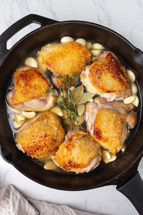 Add the garlic, wine, broth and herbs and bake