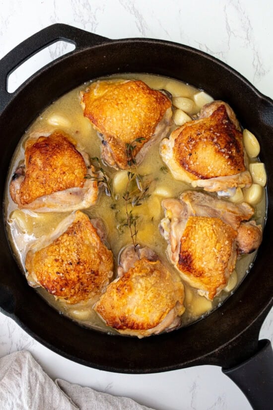 Add the garlic, wine, broth and herbs and bake