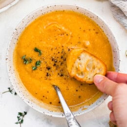 Butternut Squash Cheddar Soup in a bowl with bread
