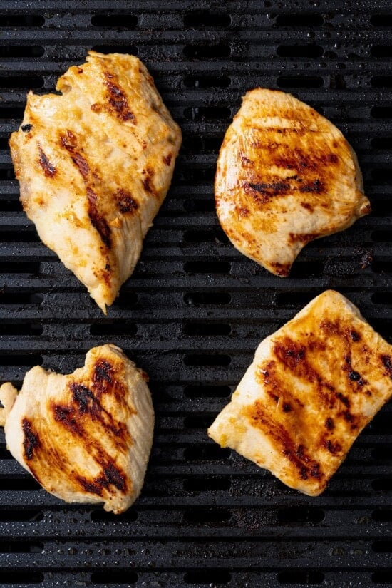 This Chick-Fil-A Egg White Grill copycat is made with juicy grilled chicken, fluffy egg whites and cheese for a hearty meal prep breakfast! Chicken breasts on grill.
