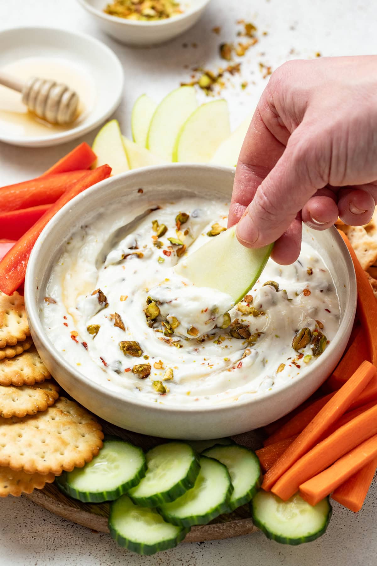 Hot Honey Whipped Feta Dip with hand and apple slice
